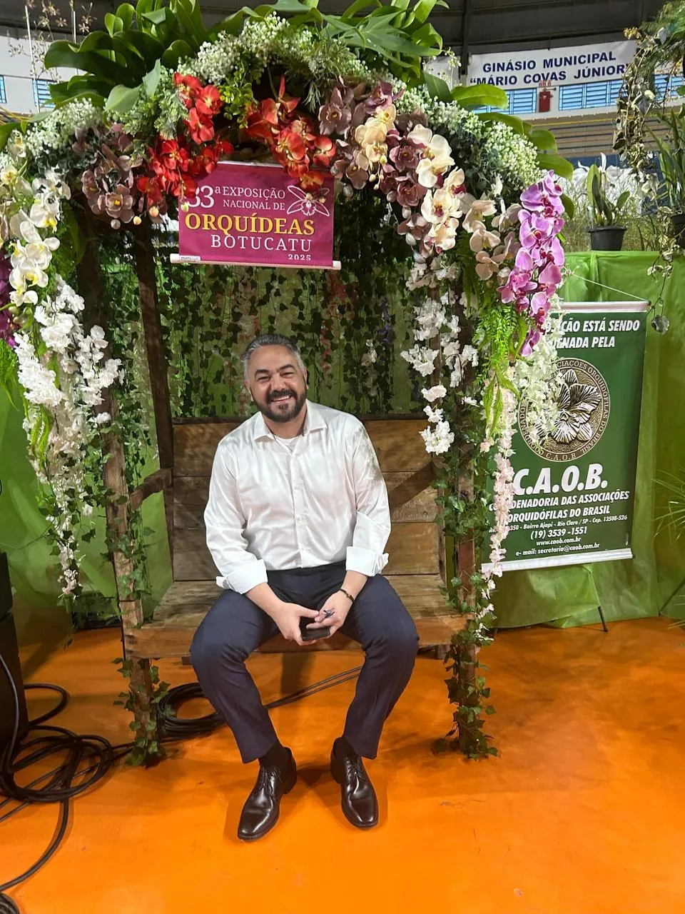 Banco decorado com arco de orquídeas e flores na 33ª Exposição Nacional de Orquídeas de Botucatu, em 2025