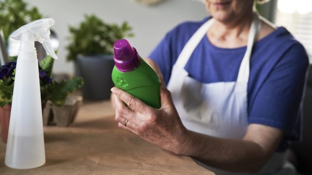Close up of woman using fertilizer for the plants